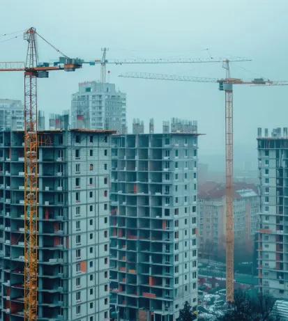 Tower cranes beside high-rise buildings under construction